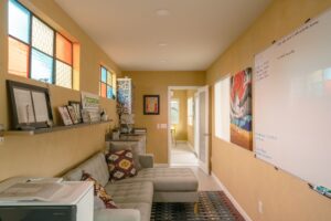 American Clay Enjarre finish in Tucson Gold, Marmoleum click in Concrete, salavaged metal windows with added stained glass, at EcoSense Sustainable Landsapers Offices- Photos by Logan Havens