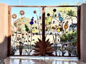 Custom Metal gate with Bedrock Industries recycled glass pieces in turquoise, tomato soup, sunshine, marmalade, European yellow, grass, and cobalt