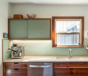 Custom cabinets made from salvaged redwood, upper cabinets faced with Marmoleum in Fresco Sage- Photo by Logan Havens
