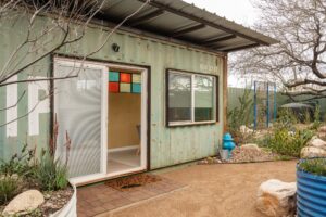 American Clay Enjarre finish in Tucson Gold, Marmoleum click in Concrete, salavaged metal windows with added stained glass, at EcoSense Sustainable Landsapers Offices- Photos by Logan Havens