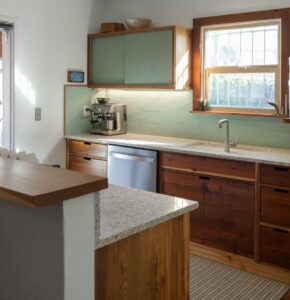 Custom cabinets made from salvaged redwood, upper cabinets faced with Marmoleum in Fresco Sage- Photo by Logan Havens